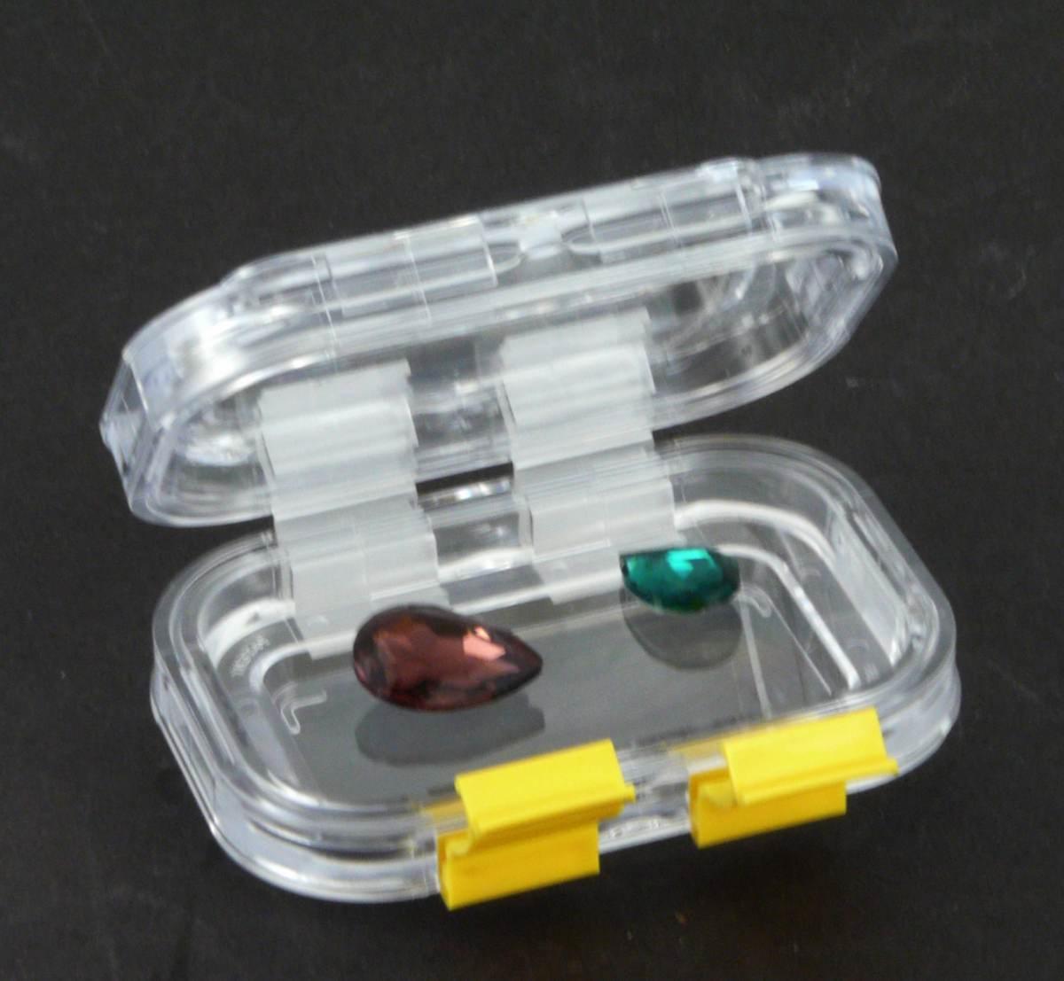 Des pierres taillées de gemmologie présentées dans une boite à membrane.